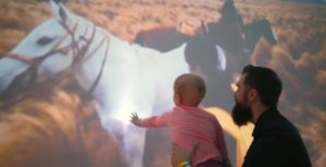 Child smiling at horse experience