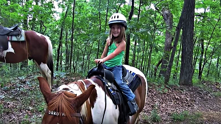 Young riders mounted on the giant horse