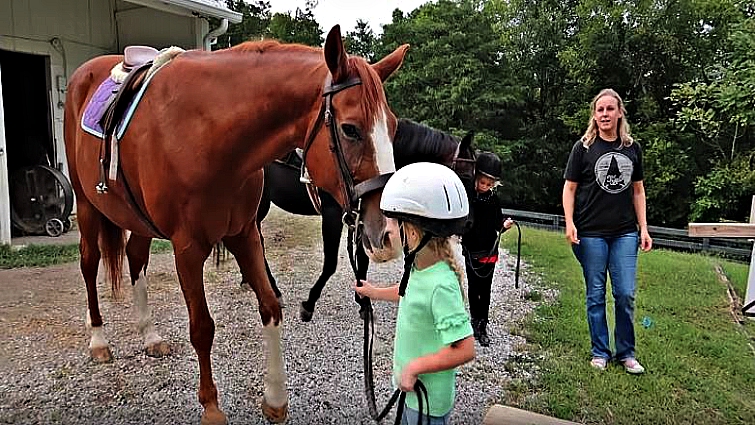 Young girl riding horse for second time