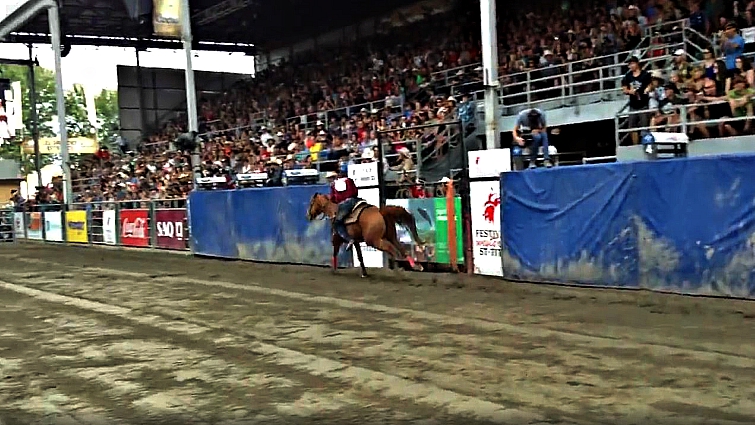 Close-up of the mid-gallop transition between riders